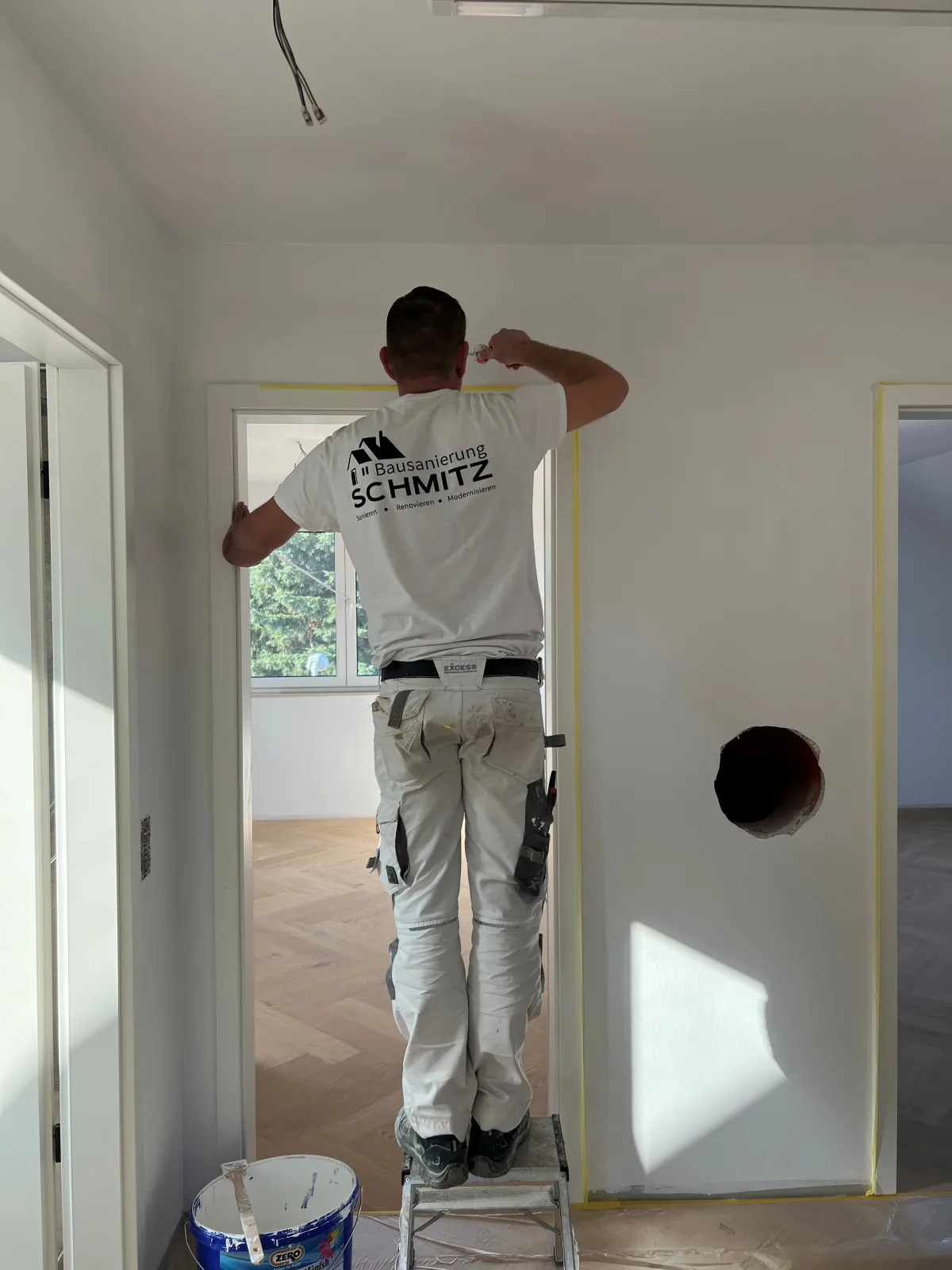 Maler von Bausanierung Schmitz streicht einen Türrahmen bei einer Renovierung in Krefeld